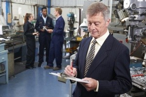 43055477 - owner of engineering factory with staff in background